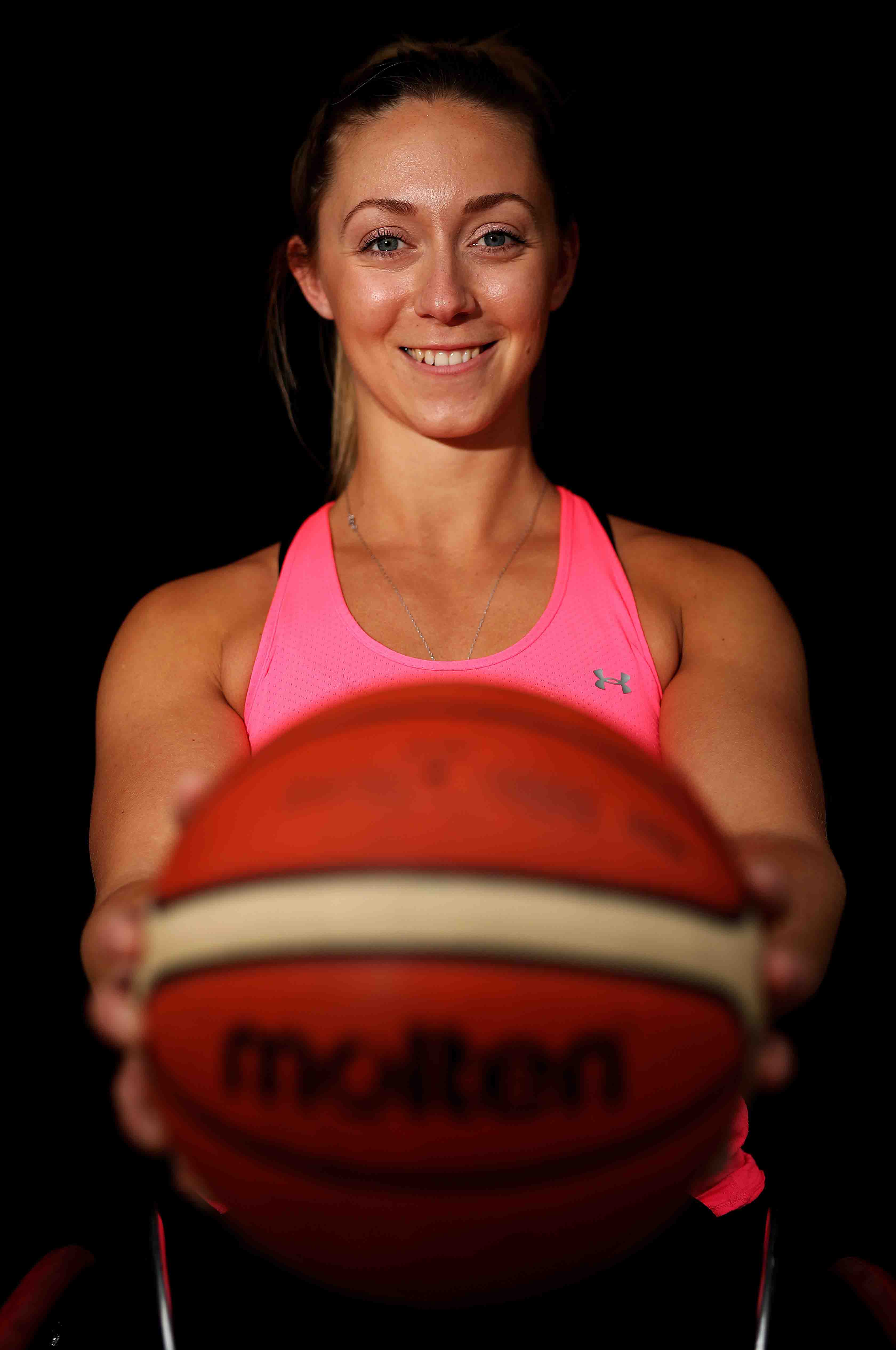 Sophie holding a basketball at arms length towards the camera.