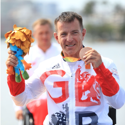 Ian smiling holding his medal.